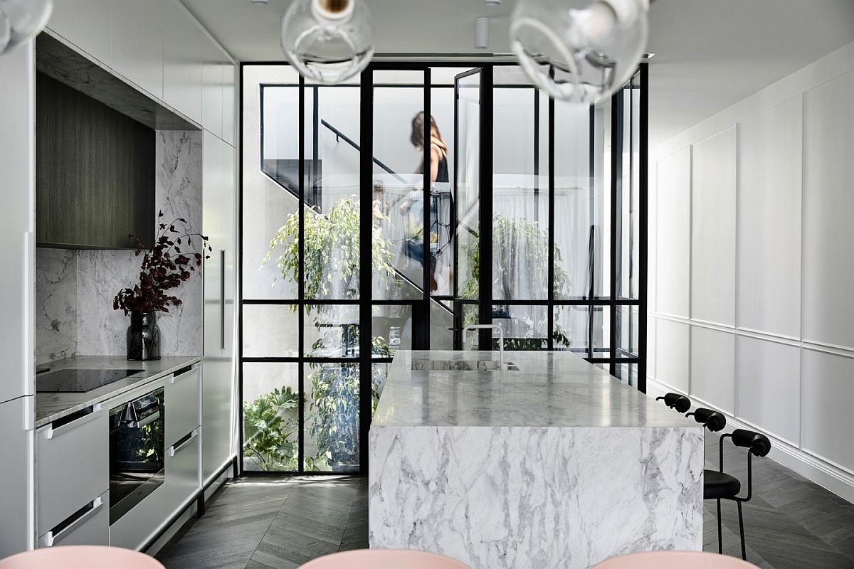 Gorgeous atrium brings light and a sense of spaciousness to the small kitchen in white