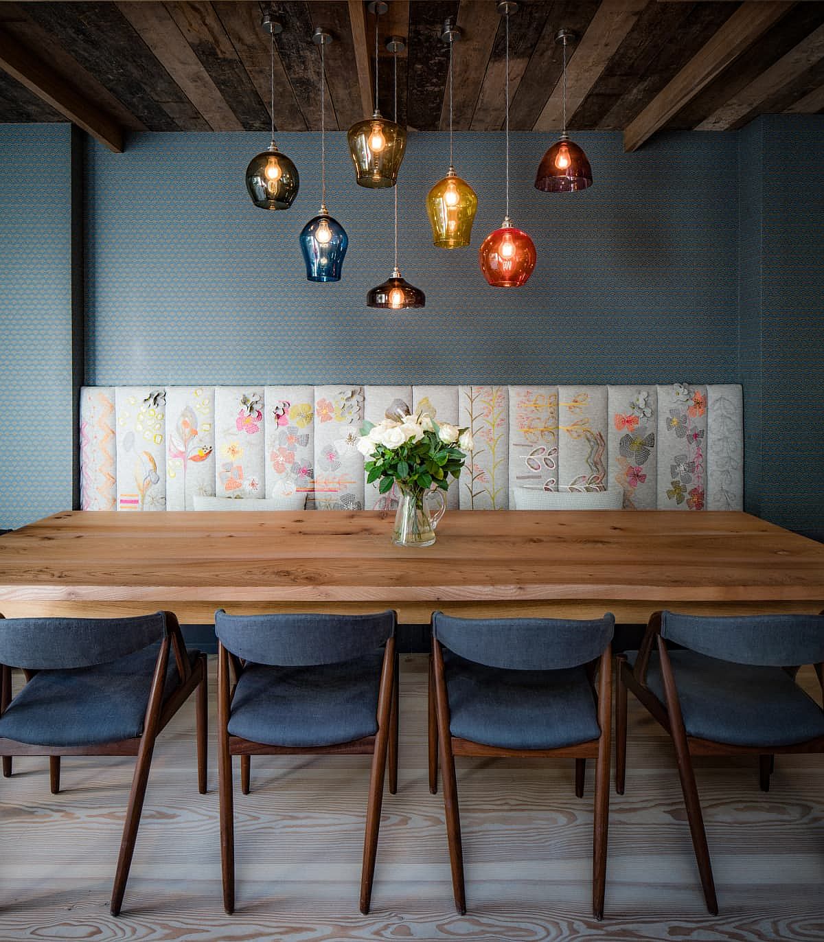 Lovely blue backdrop, multi-colored lighting and wooden ceiling for the eclectic dining space