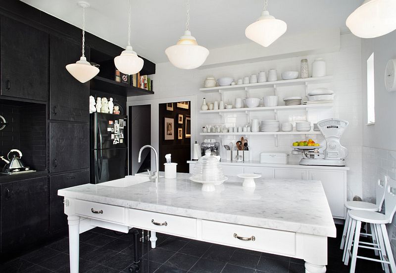 Marble kitchen countertops and black cabinets stand in contrast in the kitchen