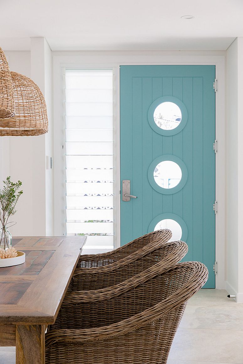 Round-windows-accentuate-the-beach-style-of-the-entry-with-light-blue-door