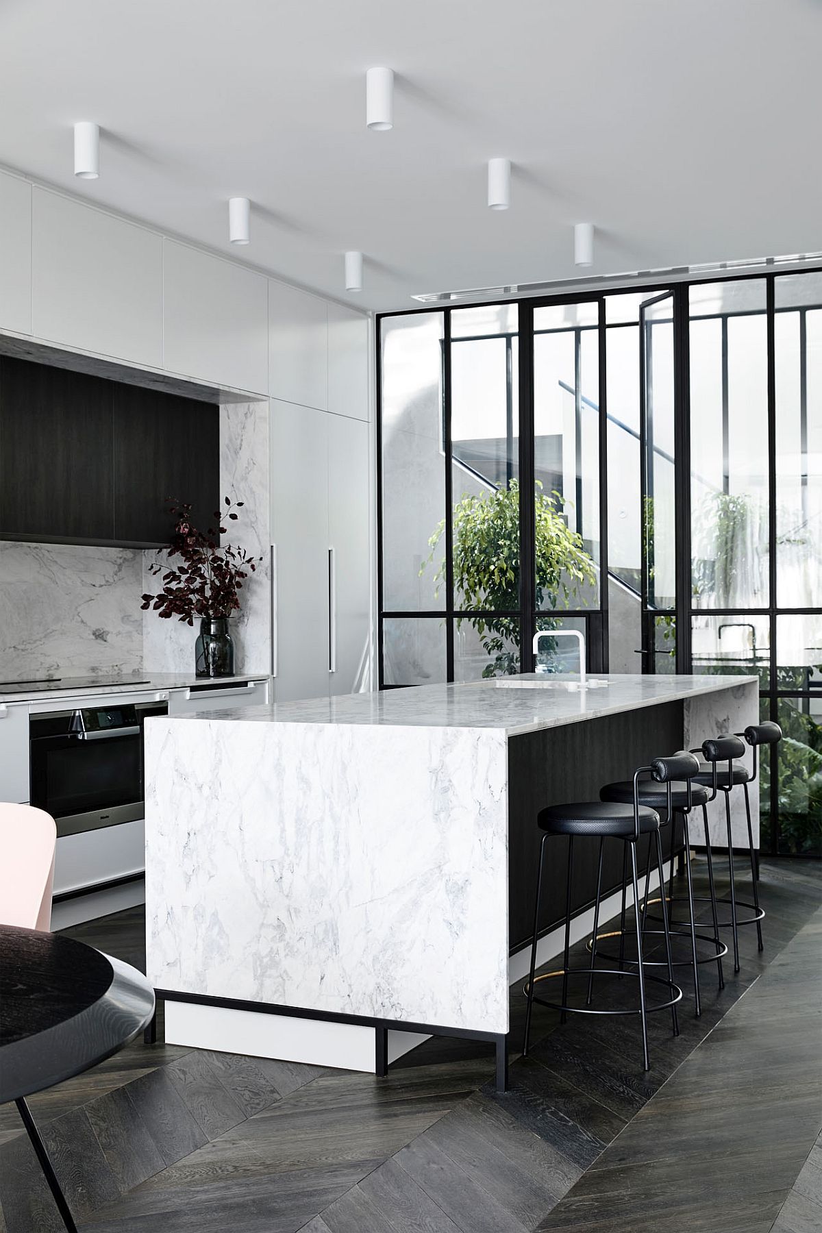 Spacious modern kitchen in black and white with marble island tops