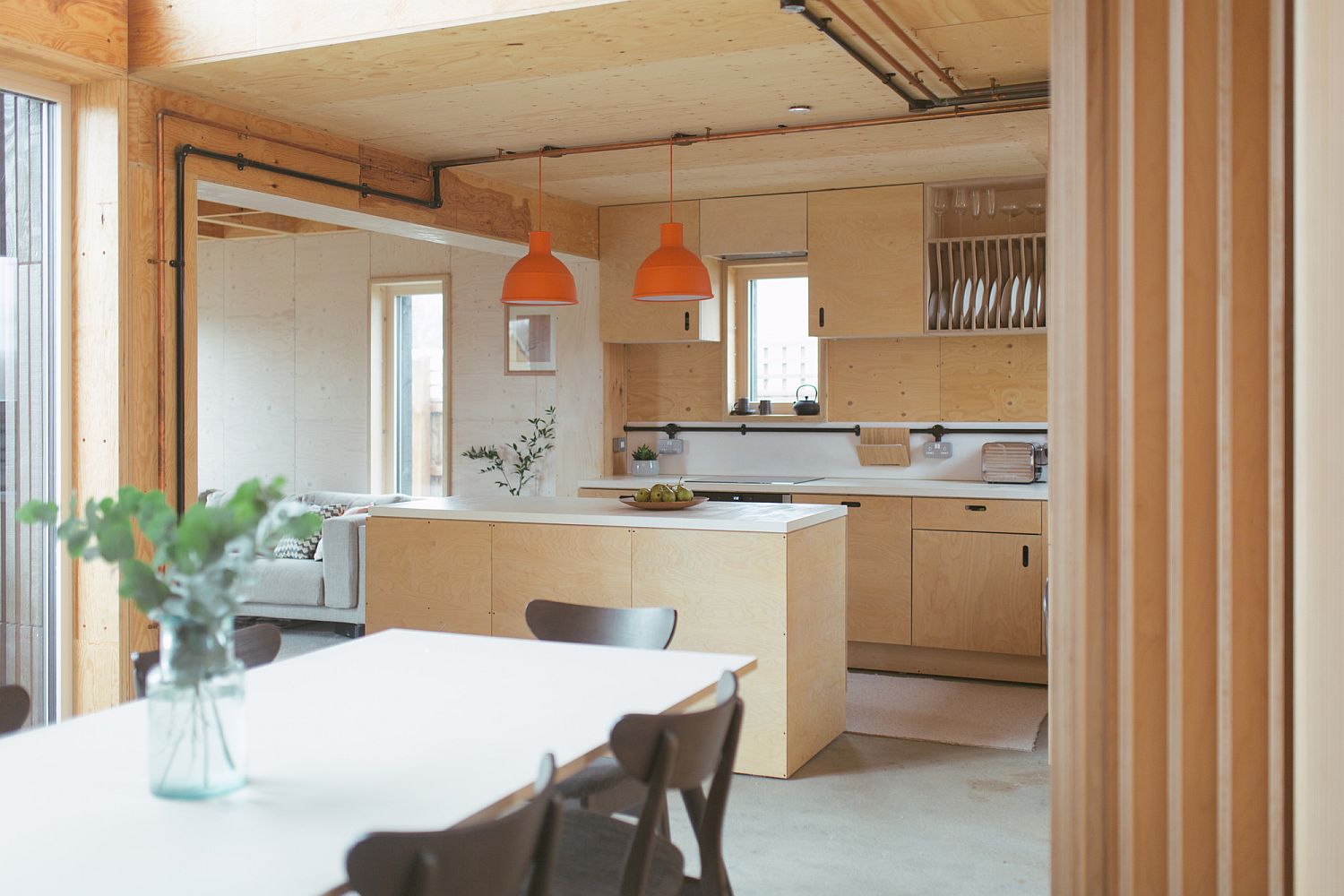 Twin orange pendants add color to the neutral kitchen space