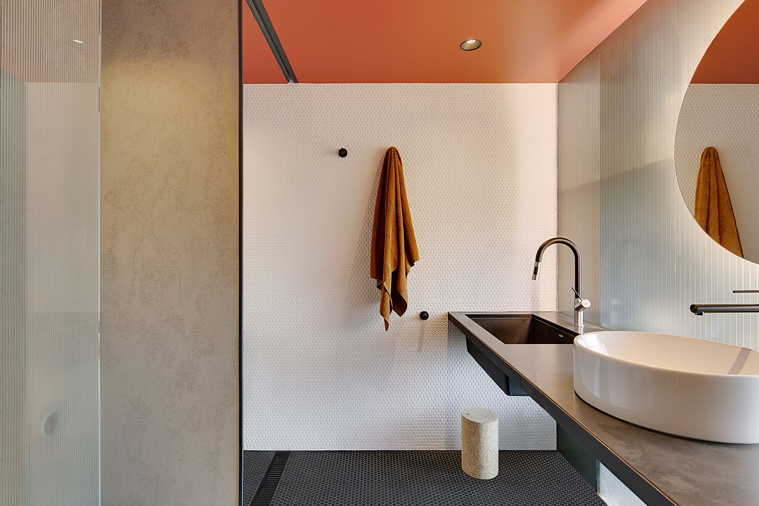 White penny tiles coupled with brilliant orange ceiling in the contemporary bathroom