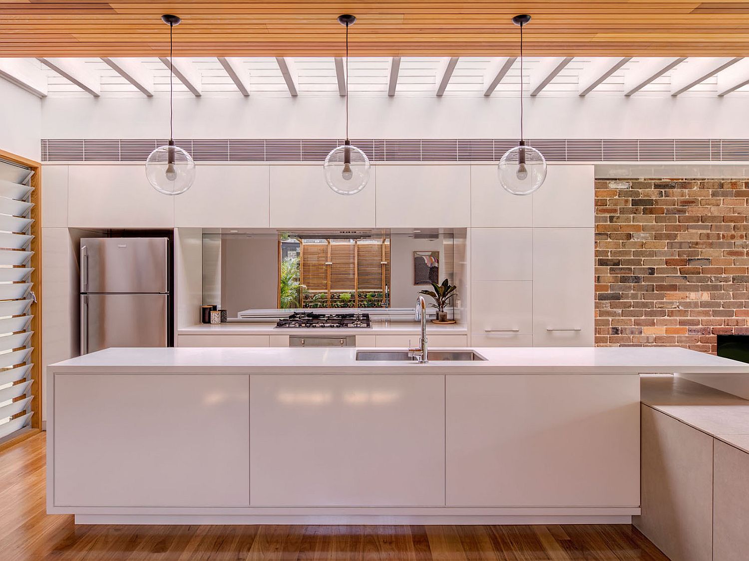 White, wood and brick kitchen of the contemporary home