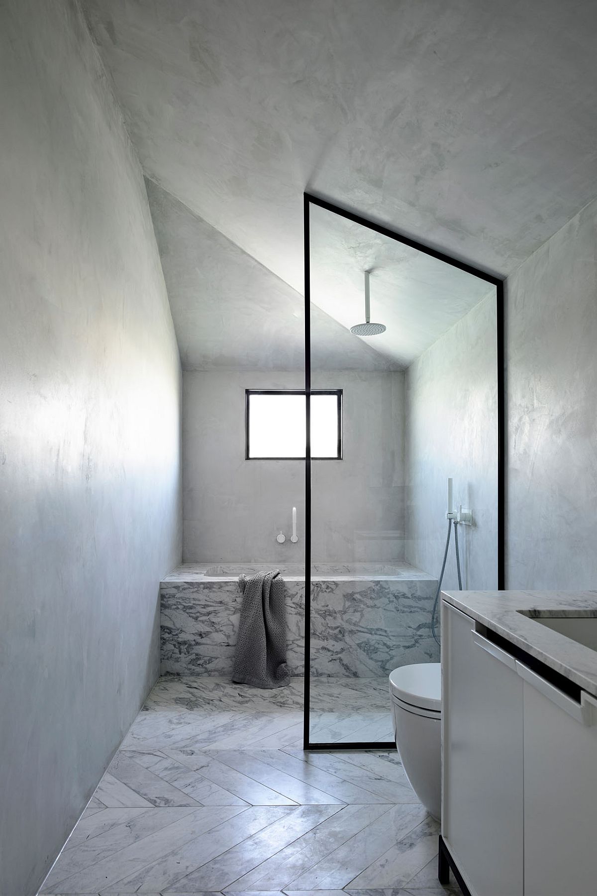 Window in the corner brings light in the minimal white bathroom