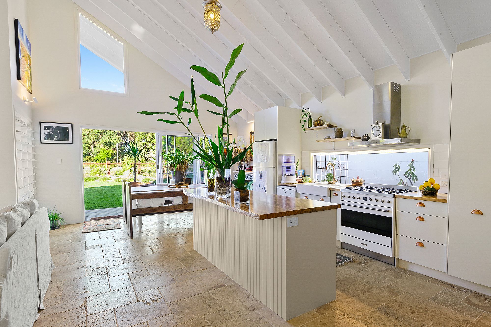 Gorgeous white beach style kitchen with ample natural light and connectivity with outdoors