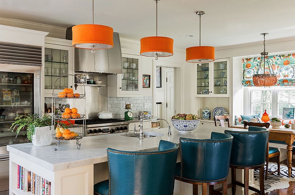 Pendants bring orange to the kitchen while the high and plush bar chairs add blue