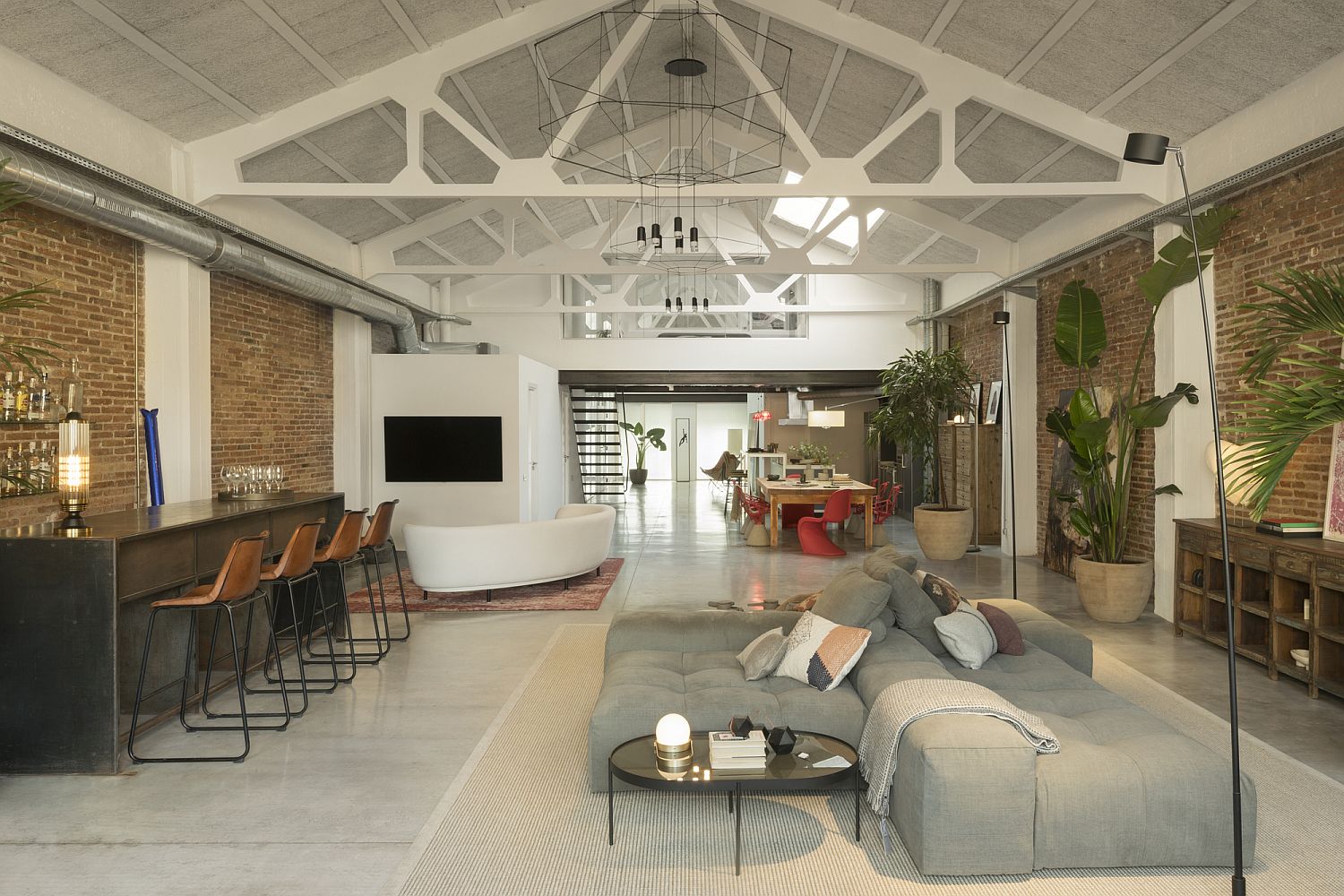 Delightful vaulted ceiling in white adds contemporary appeal to the industrial loft