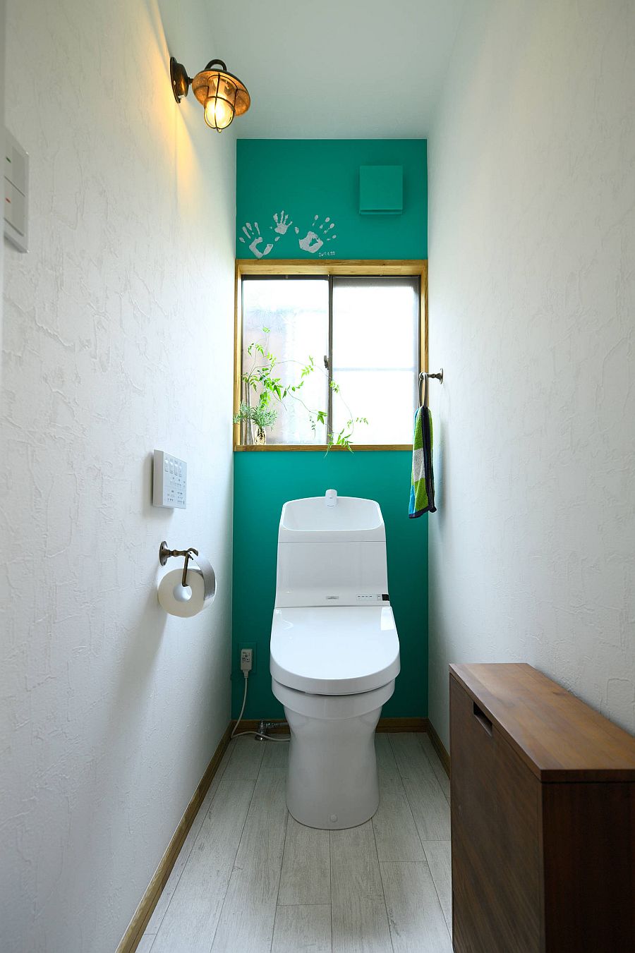 Narrow powder room with a striking accent wall in dark green