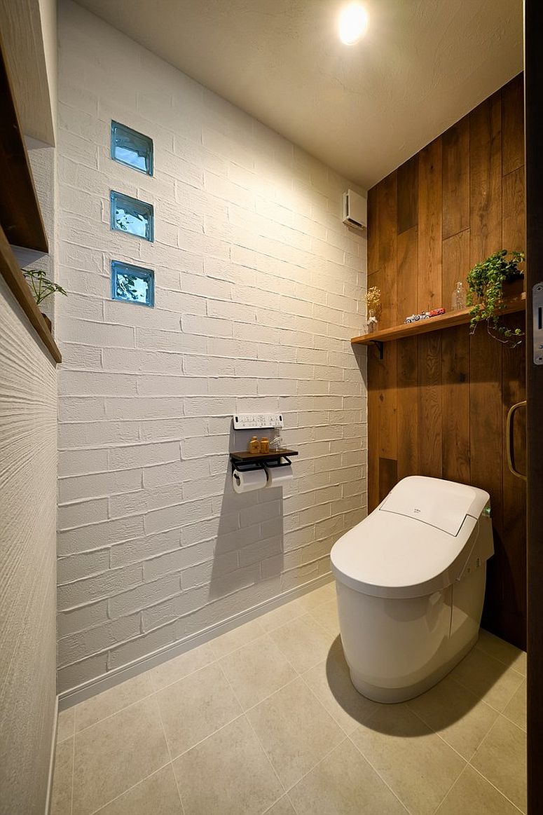 Painted brick wall and wood wall coupled in style inside the small powder room