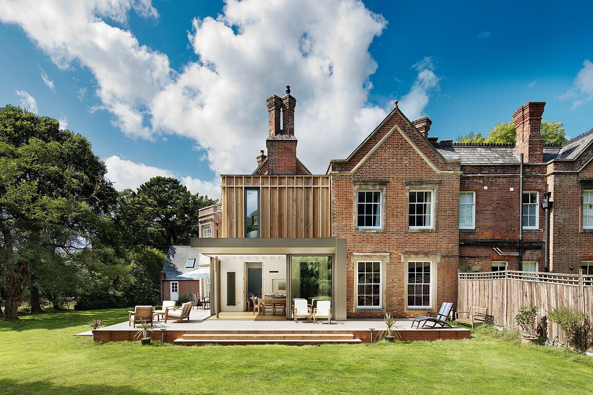 Rear extension of the house with a large wooden deck and dining room next to it