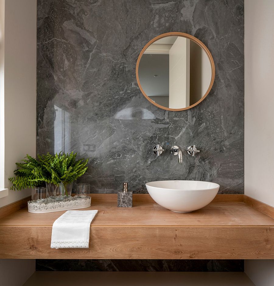 Slim floating vanity in wood with accent wall in stone