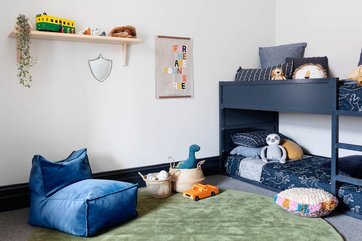 Smart little bunk bed in blue in the corner keeps things casual and efficient