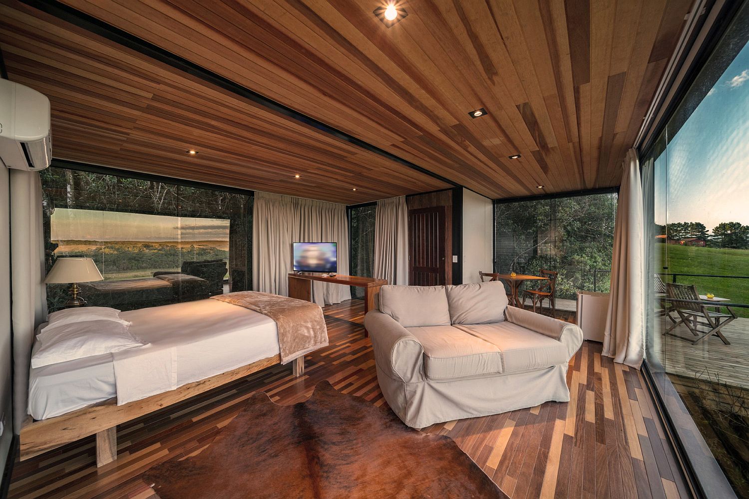 Wood and glass bedroom of the cabin with wonderful view of the landscape around it