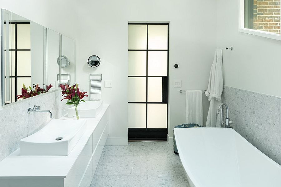 Black of the door anchors the white bathroom and defines it beautifully