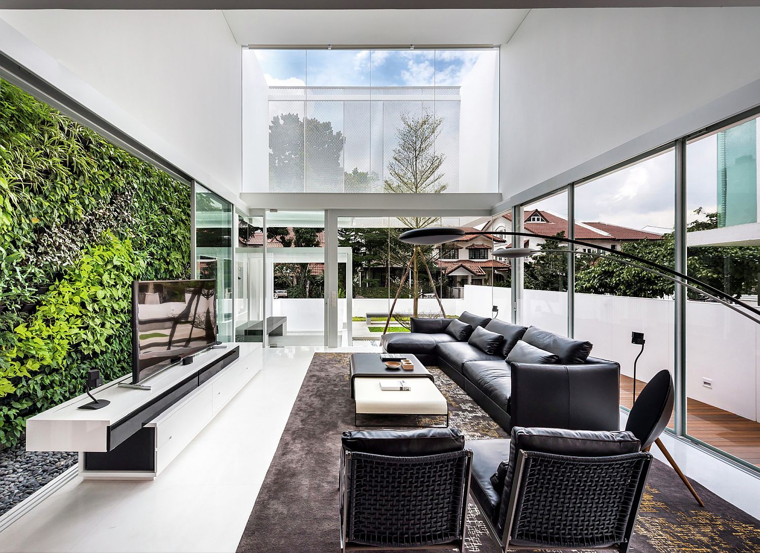 Living-room-with-green-wall-in-the-backdrop-and-ample-natural-light