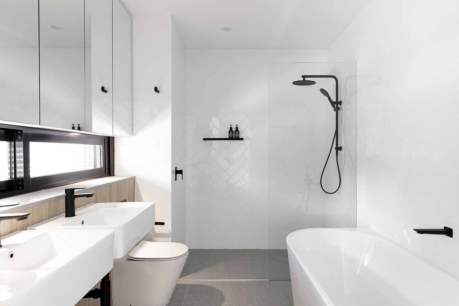 All white bathroom of the house with pops of light wood and black thrown into the mix