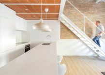 All-white-kitchen-under-the-mezzanine-level-with-wooden-ceiling-above-217x155