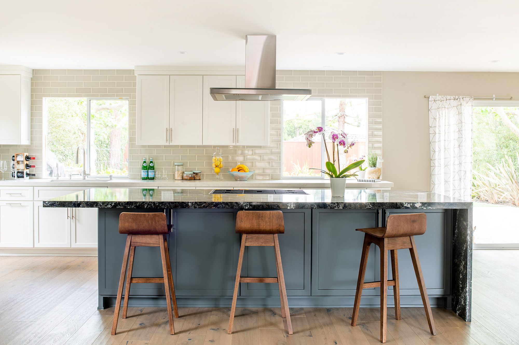 An accent island in bluish-gray for the transitional kitchen in white and gray