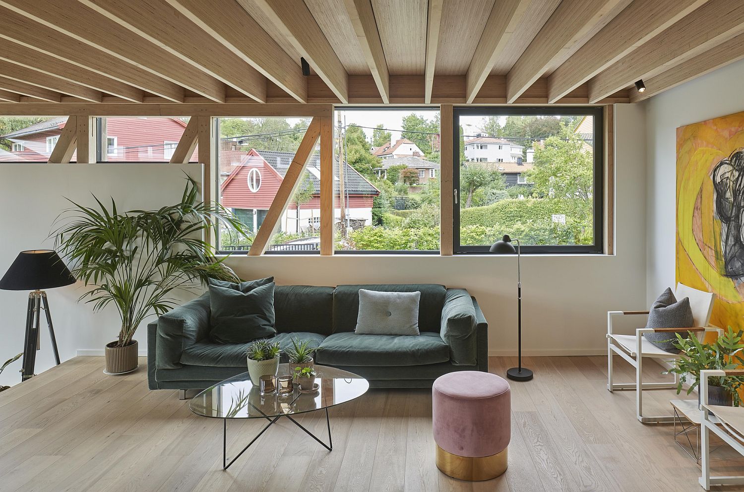 Bright couch and wall art bring color to an otherwise neutral living room in wood and white