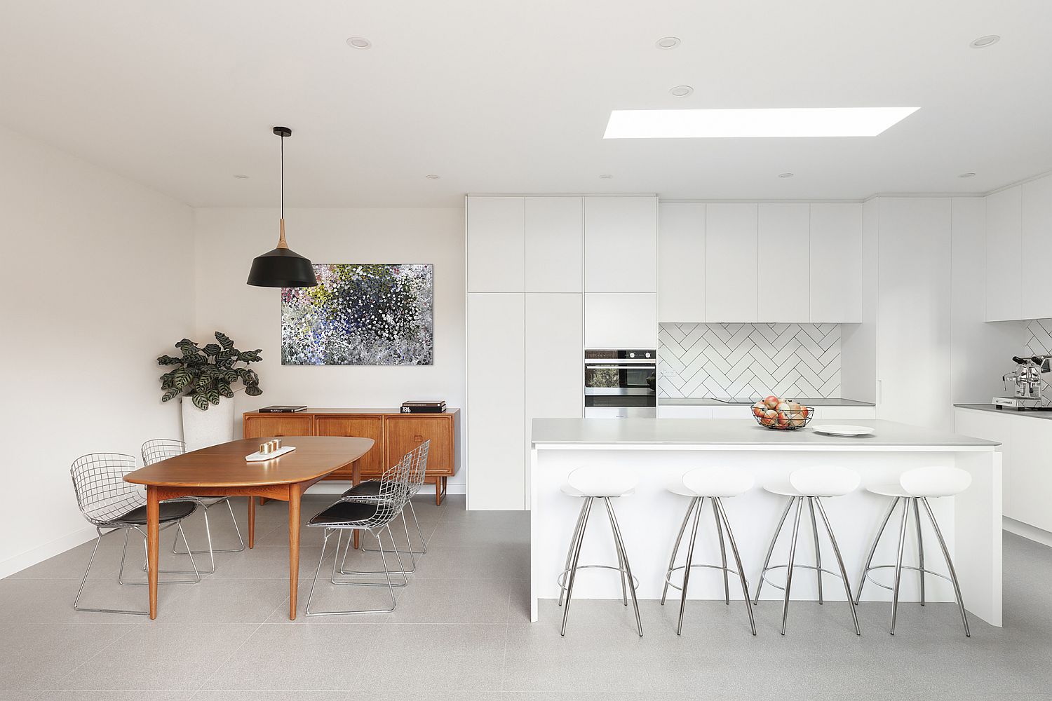 Gorgeous kitchen in white with wooden dining table that stands out visually