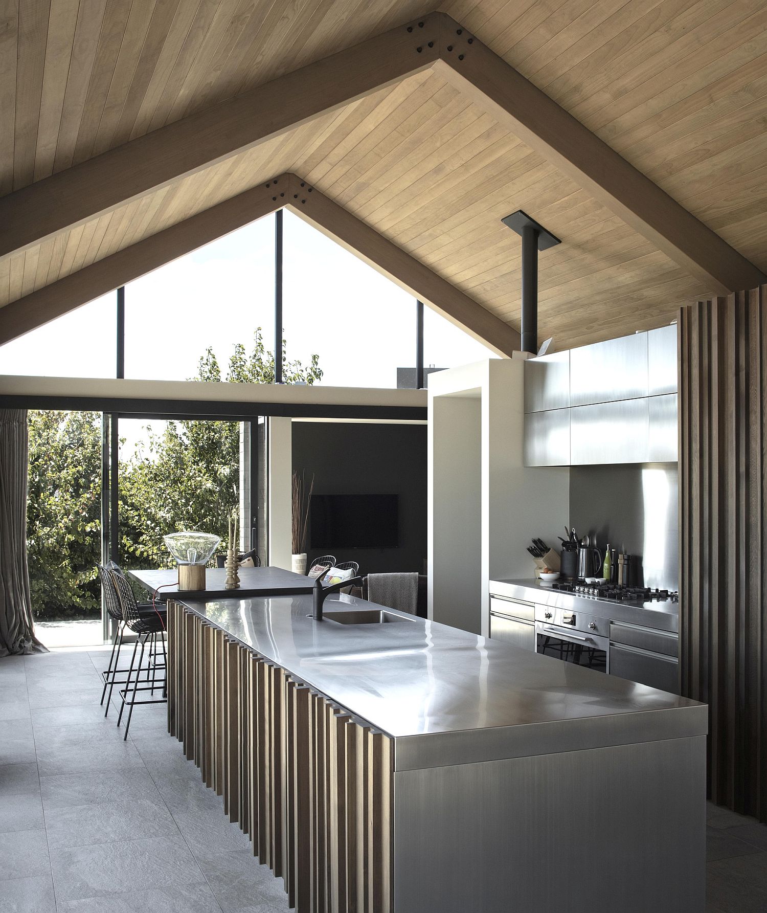 Gray interior of the kitchen with gabled roof and glass walls that bring light inside