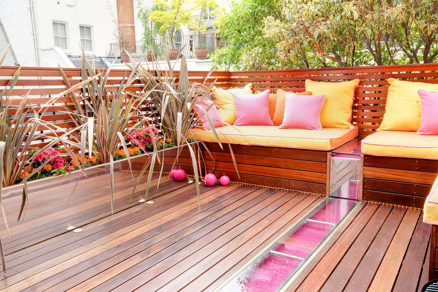 Throw pillows bring pink ad orange to the outdoor deck