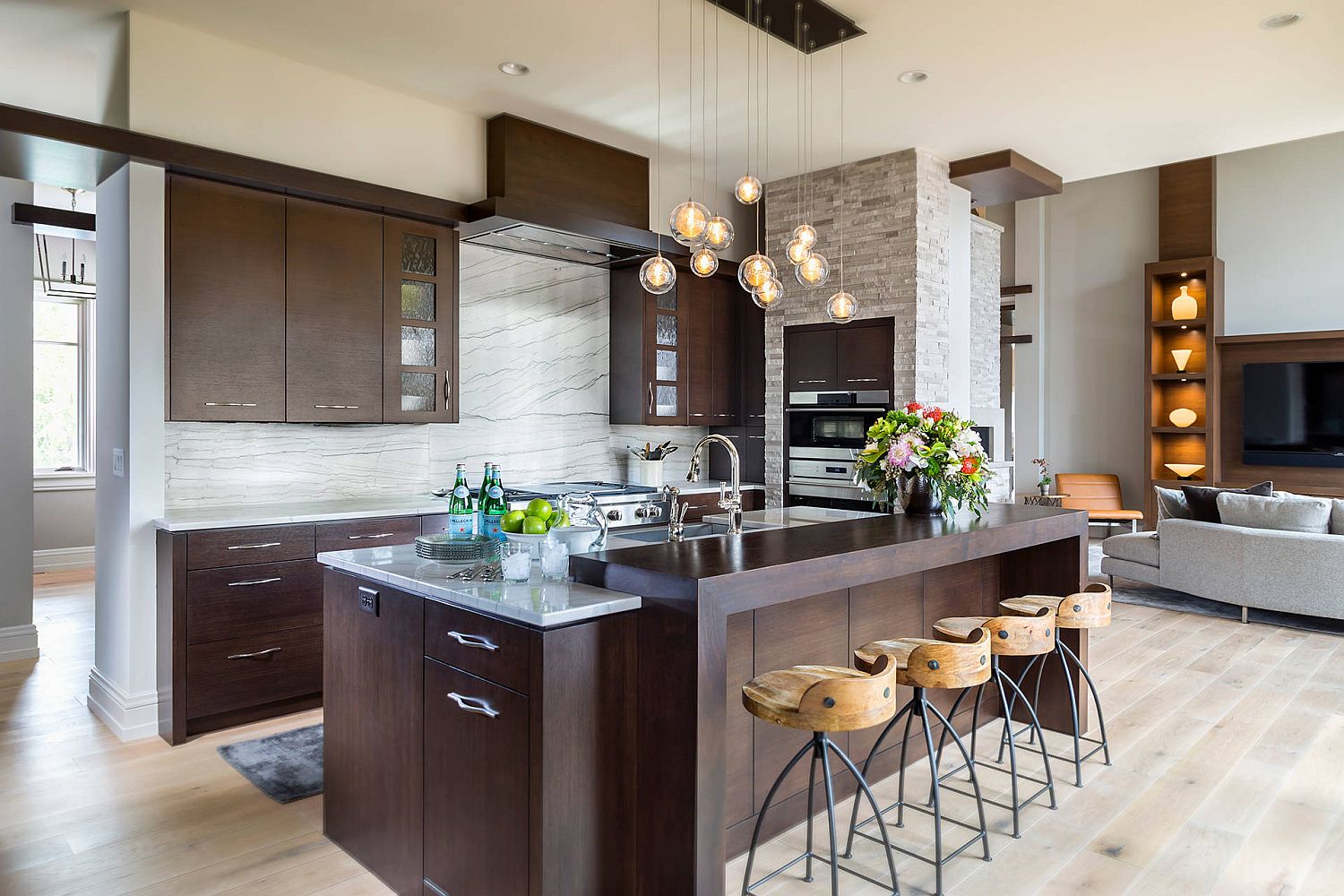 Beautiful industrial style bar stools add a different textural charm to this dark modern kitchen