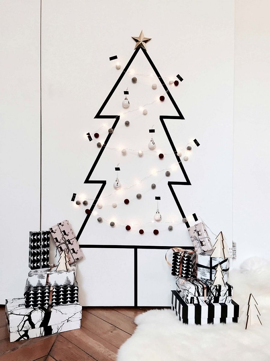 Black Christmas tree made of tape on white wall.
