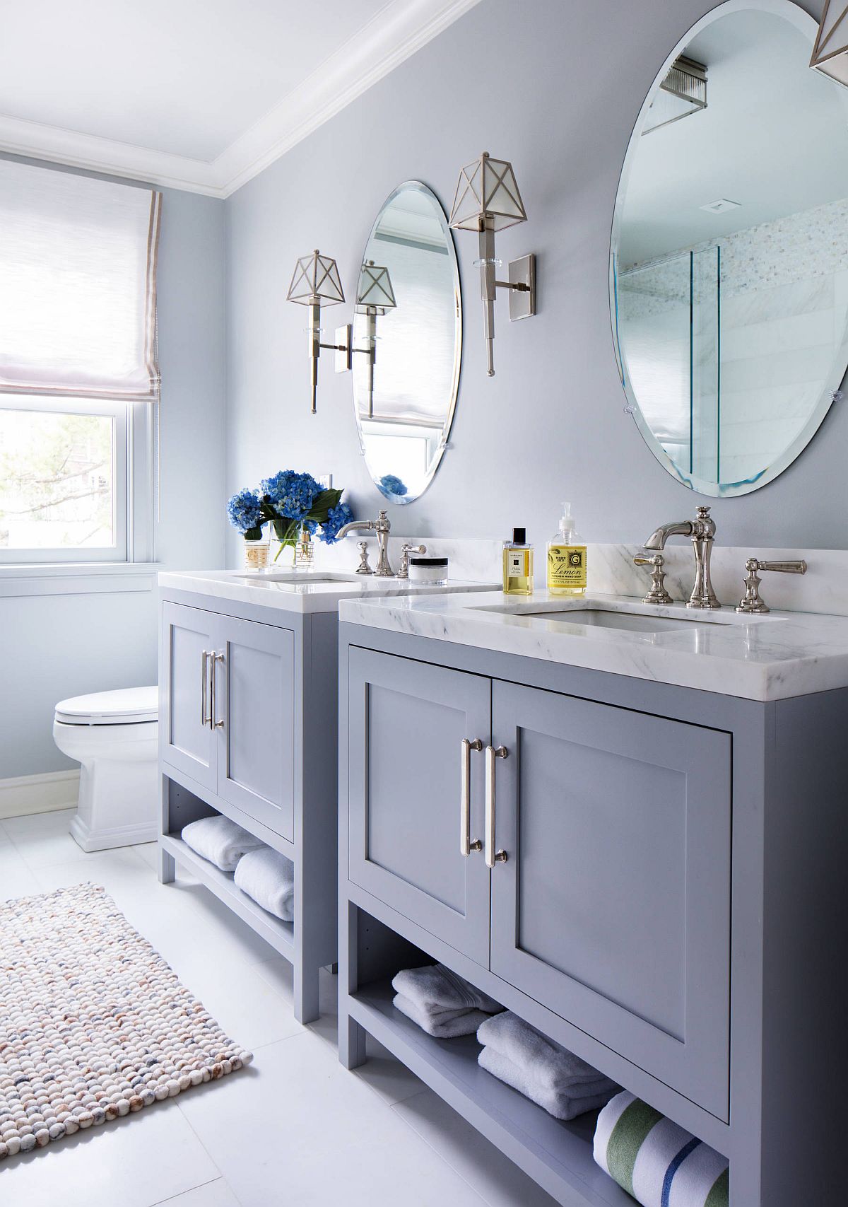 Blueish grey bathroom with double vanities.