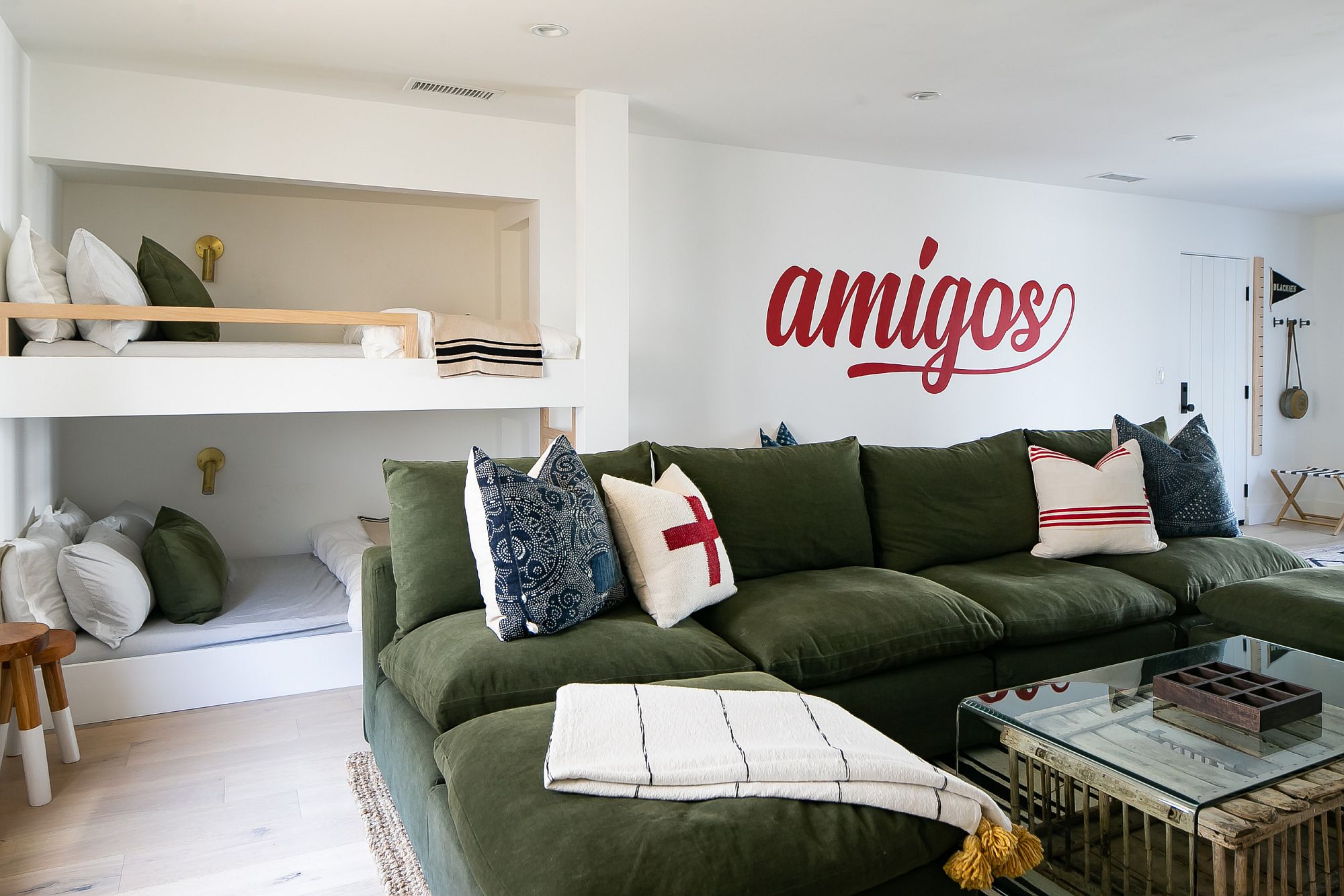 Bunk beds in the corner of the kids' bedroom with a bright couch in green