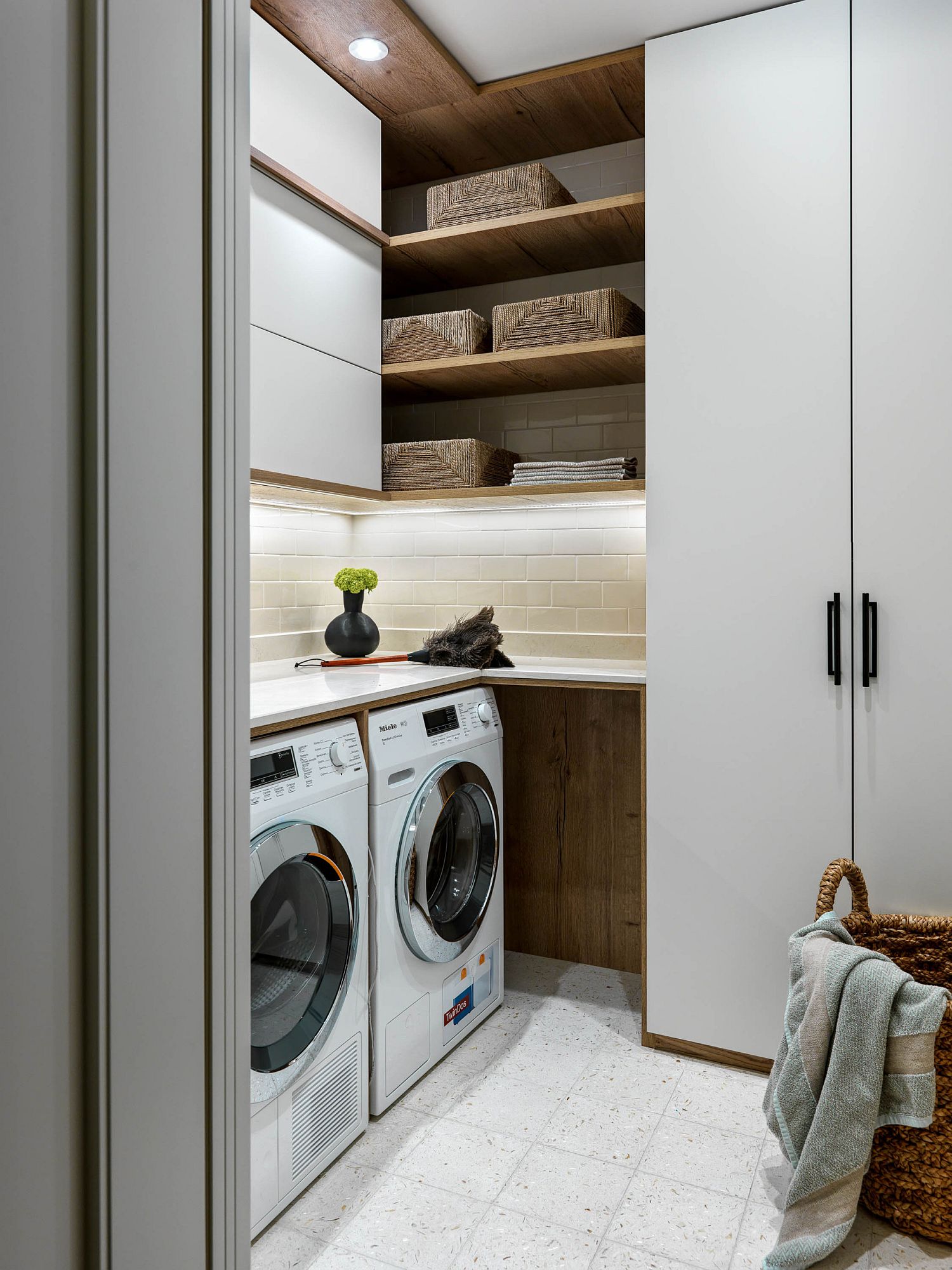 minimalist laundry room with sleek white floor to ceiling cabinets