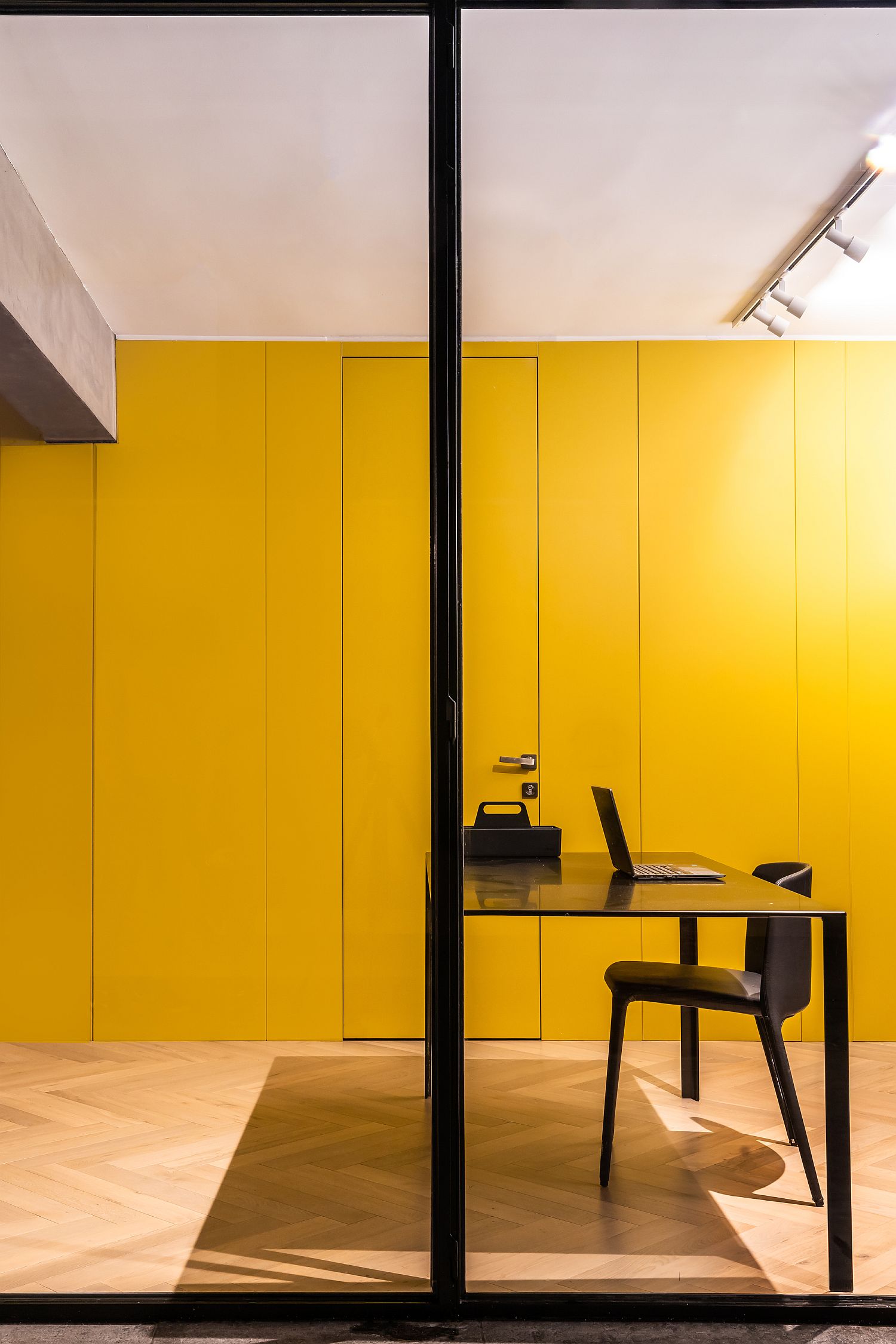 Custom mustard yellow wall in wood hides bathrooms and bedrooms behnd it