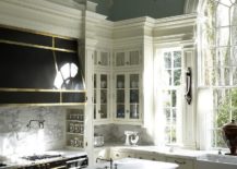 Dark-hood-in-black-with-metal-finishes-stands-in-contrast-to-the-white-marble-backsplash-217x155