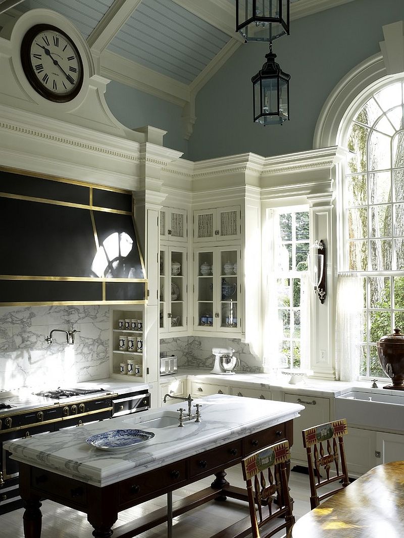 Dark hood in black with metal finishes stands in contrast to the white marble backsplash