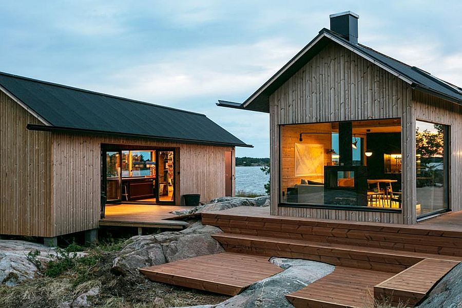 Dark roofs of the cabin stand in contrast to the light woodsy tone of the cabin itself