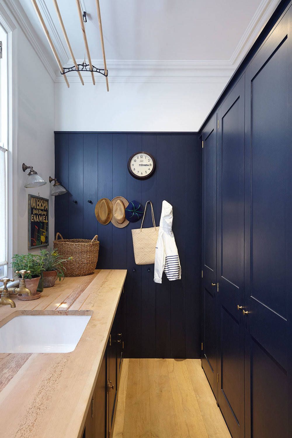 deep blue cabinets flank a galley style laundry room