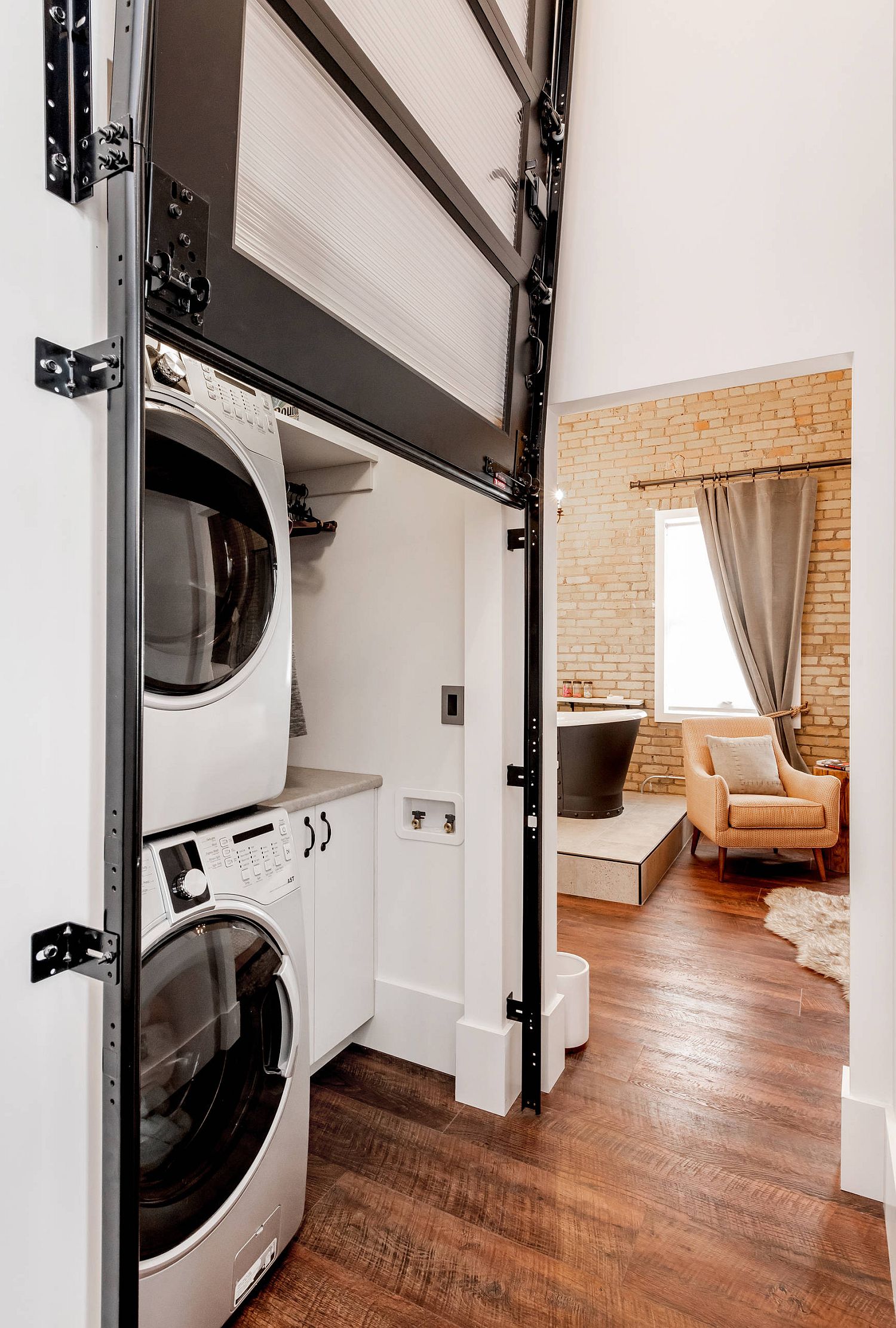 stacked washer and dryer concealed by garage style door