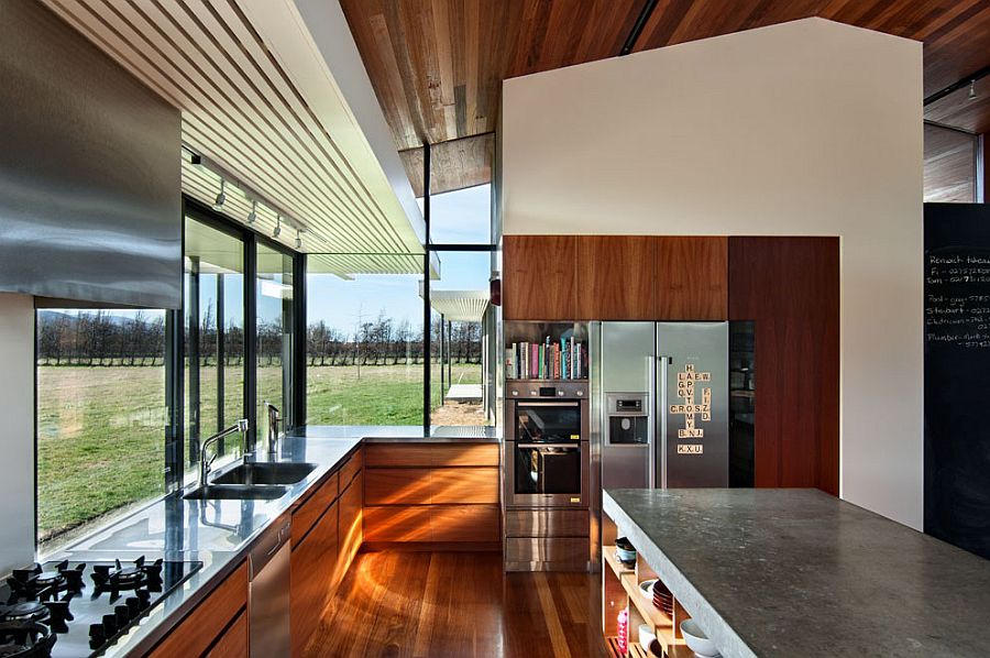 Glass windows bring ample natural light into the kitchen giving it a light visual appeal