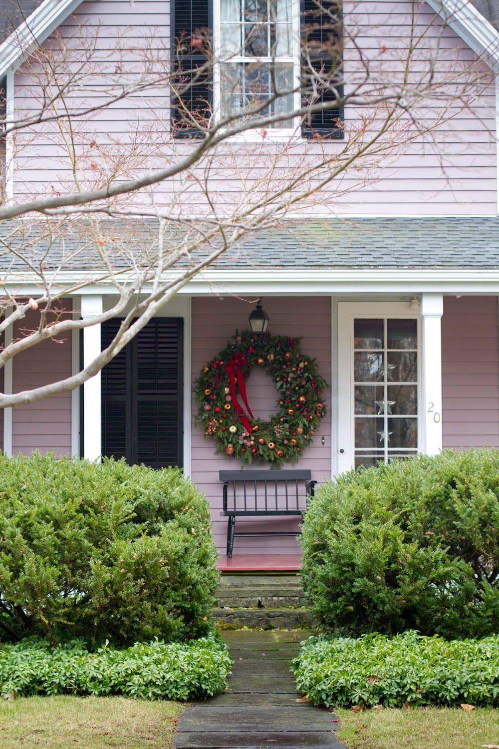 Large wreath brings festive cheer to the front porch of this charming New York home