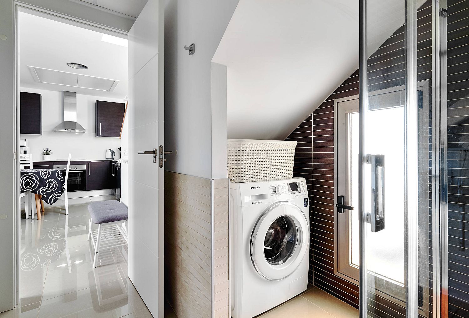 washing machine tucked into corner of bathroom with sloped ceiling