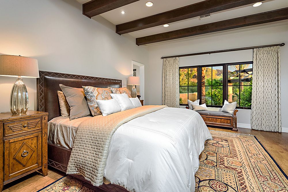 Mediterranean-style-bedroom-with-dark-wooden-ceiling-beams-and-a-neutral-color-scheme