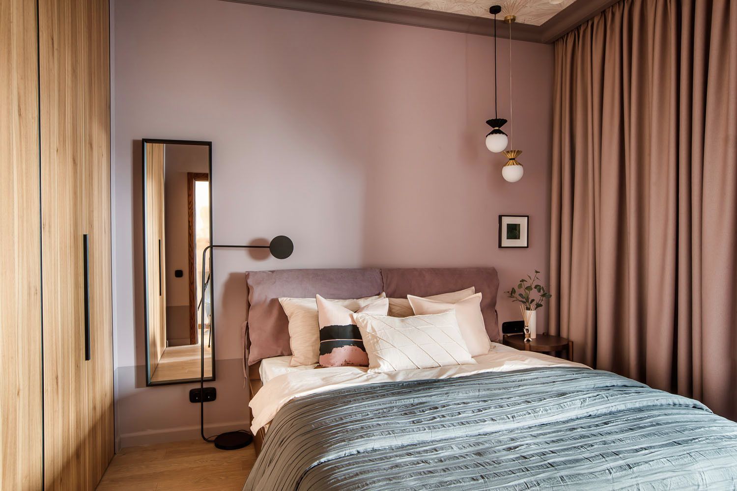 Pastel pink and woodsy cabinet give this modern Scandinavian bedroom a different visual appeal