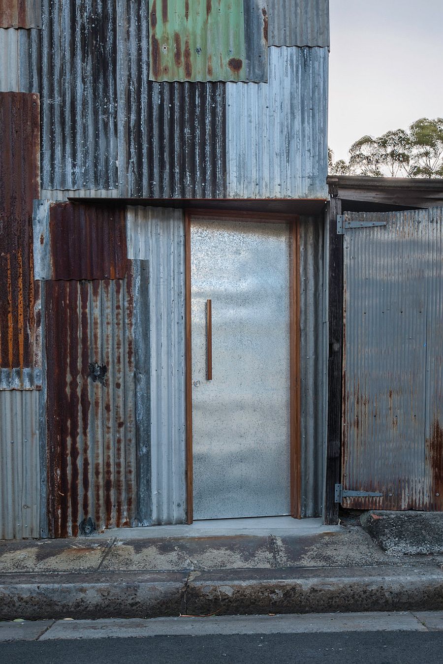 Pieces from the original disassembled tin shed cover the new facade