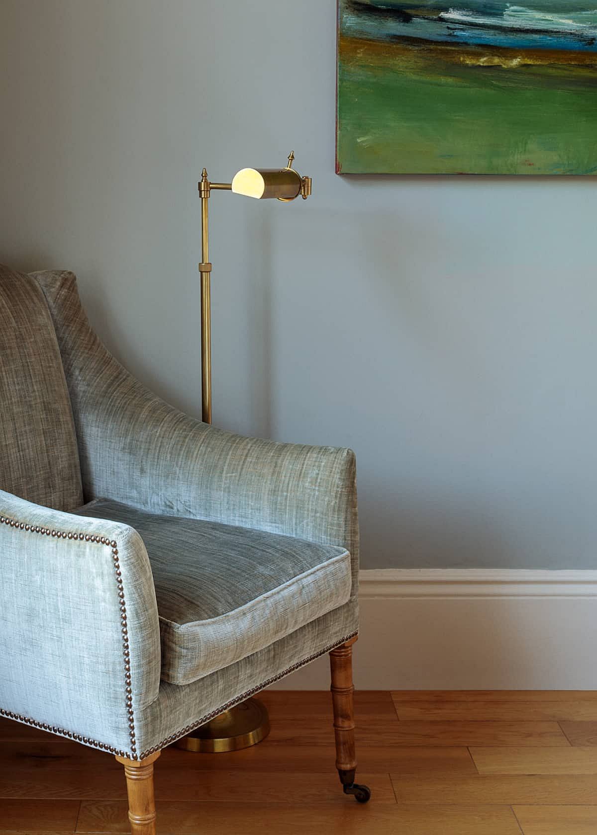 Reading nook with comfy chair and slim floor lamp that brings metallic glitz