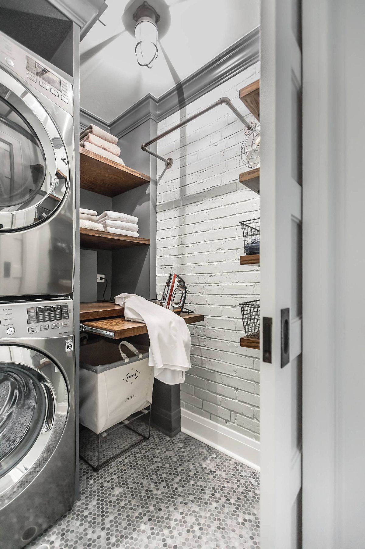 industrial style laundry room with wood shelves that roll out