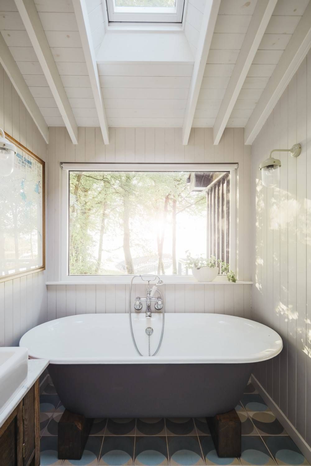 Skylight brings ample natural light into the small bathroom with tiled floor