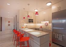 Snazzy-red-bar-stools-with-geometric-charm-and-pendant-lights-bring-color-to-this-ergonomic-modern-kitchen-217x155