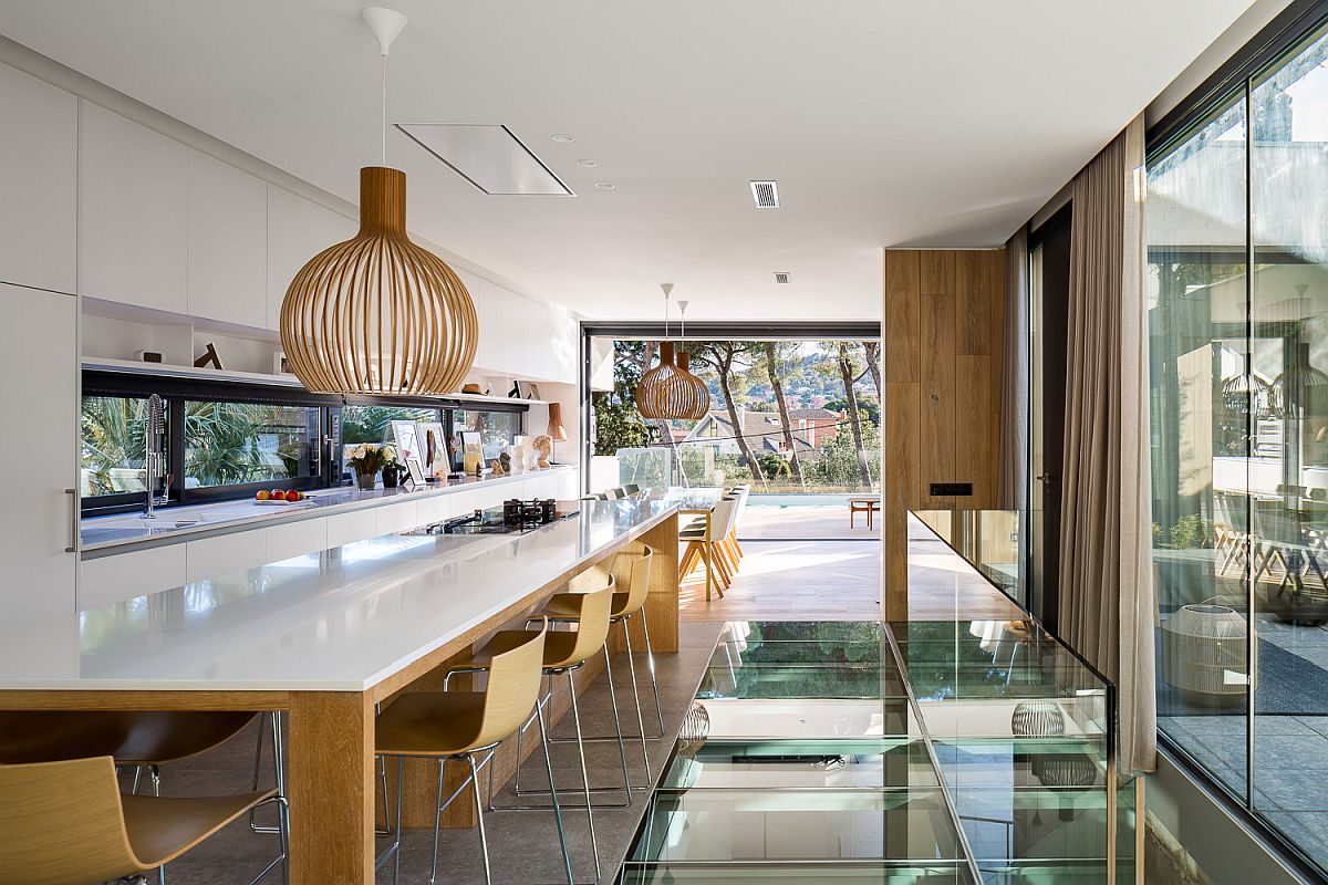 Spacious-wood-and-white-kitchen-and-dining-space-that-offers-perfect-vantage-point-inside-the-house