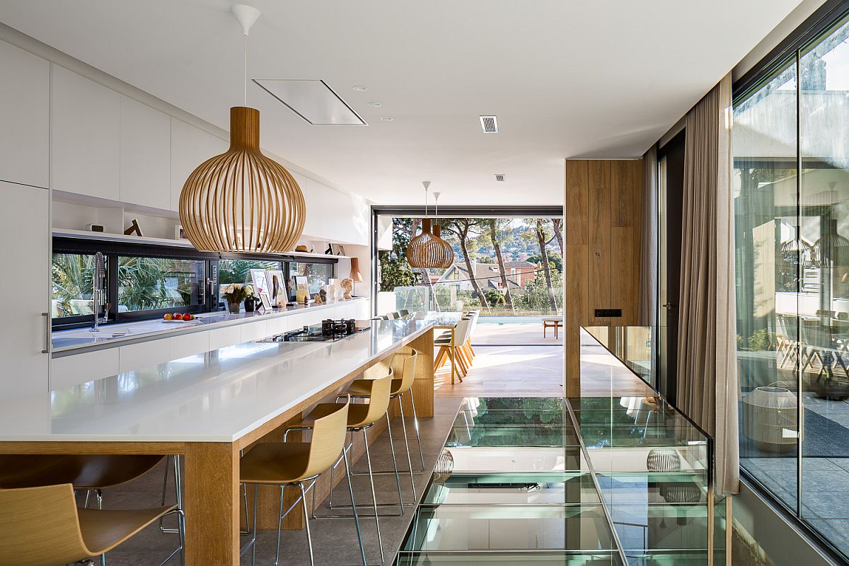 Spacious wood and white kitchen and dining space that offers perfect vantage point inside the house